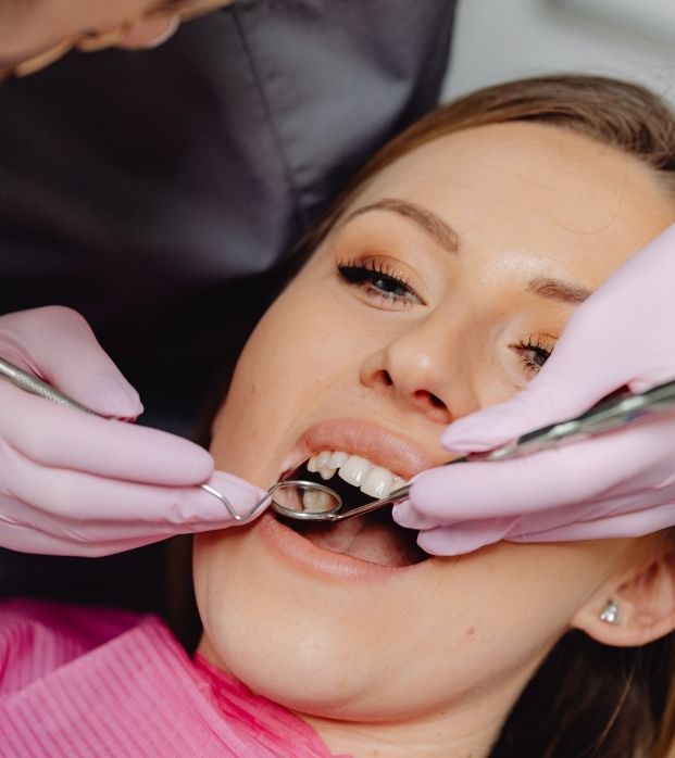 A hygienist cleaning along a patient's gumline