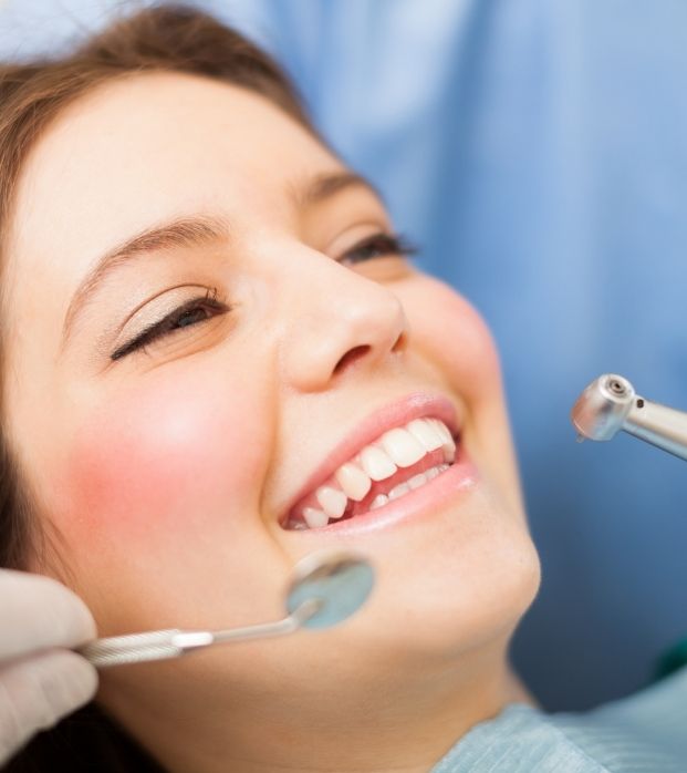 A smiling patient receiving a fluoride treatment