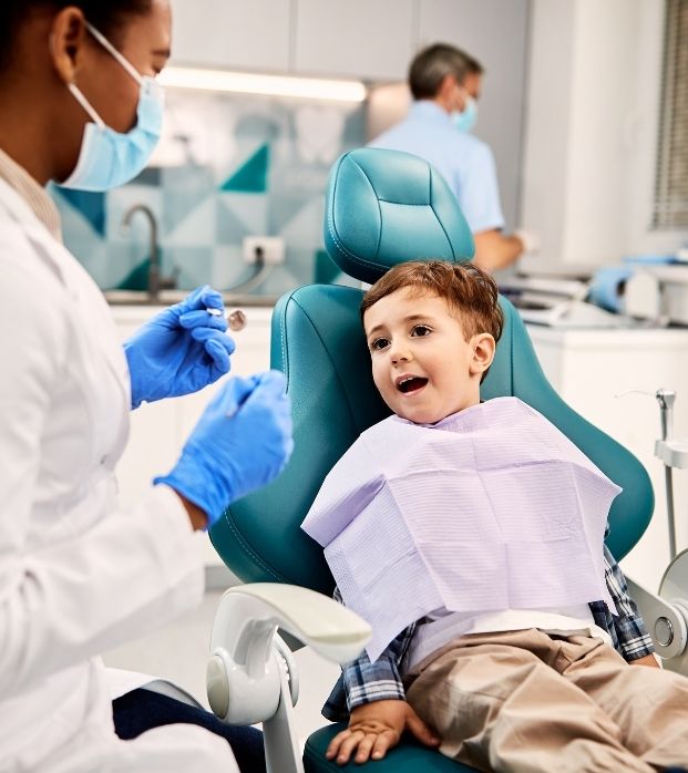 A young boy giving a thumbs-up in the dental chair