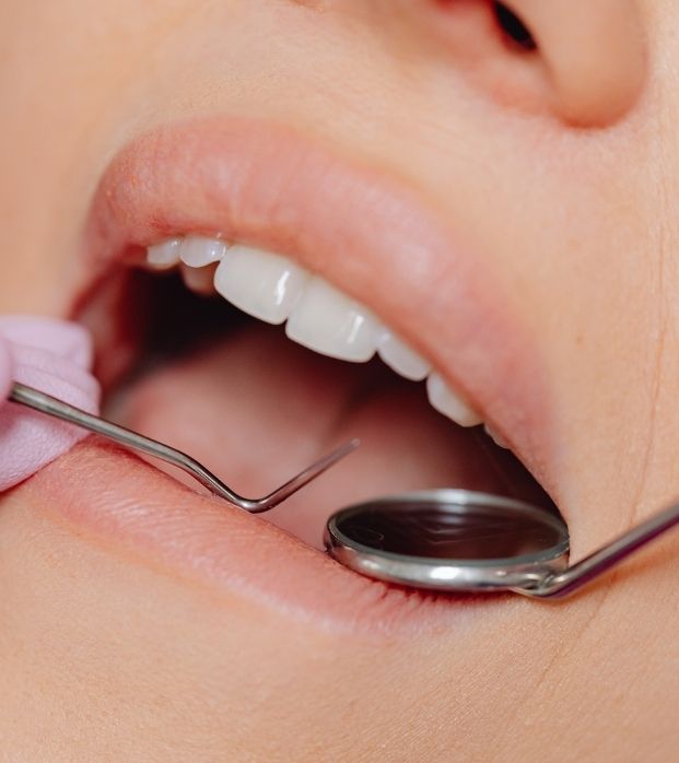 A dentist examining a patient's gums with a mirror