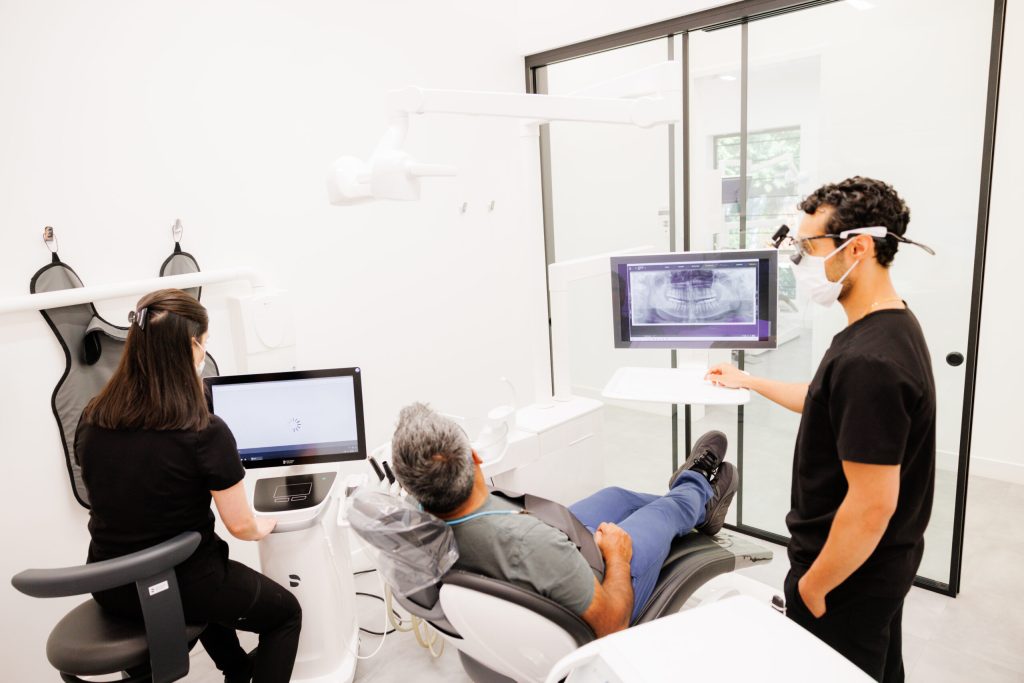 A Green Apple Dental clinician reviewing a patient&rsquo;s 3D scan on the screen at the chair