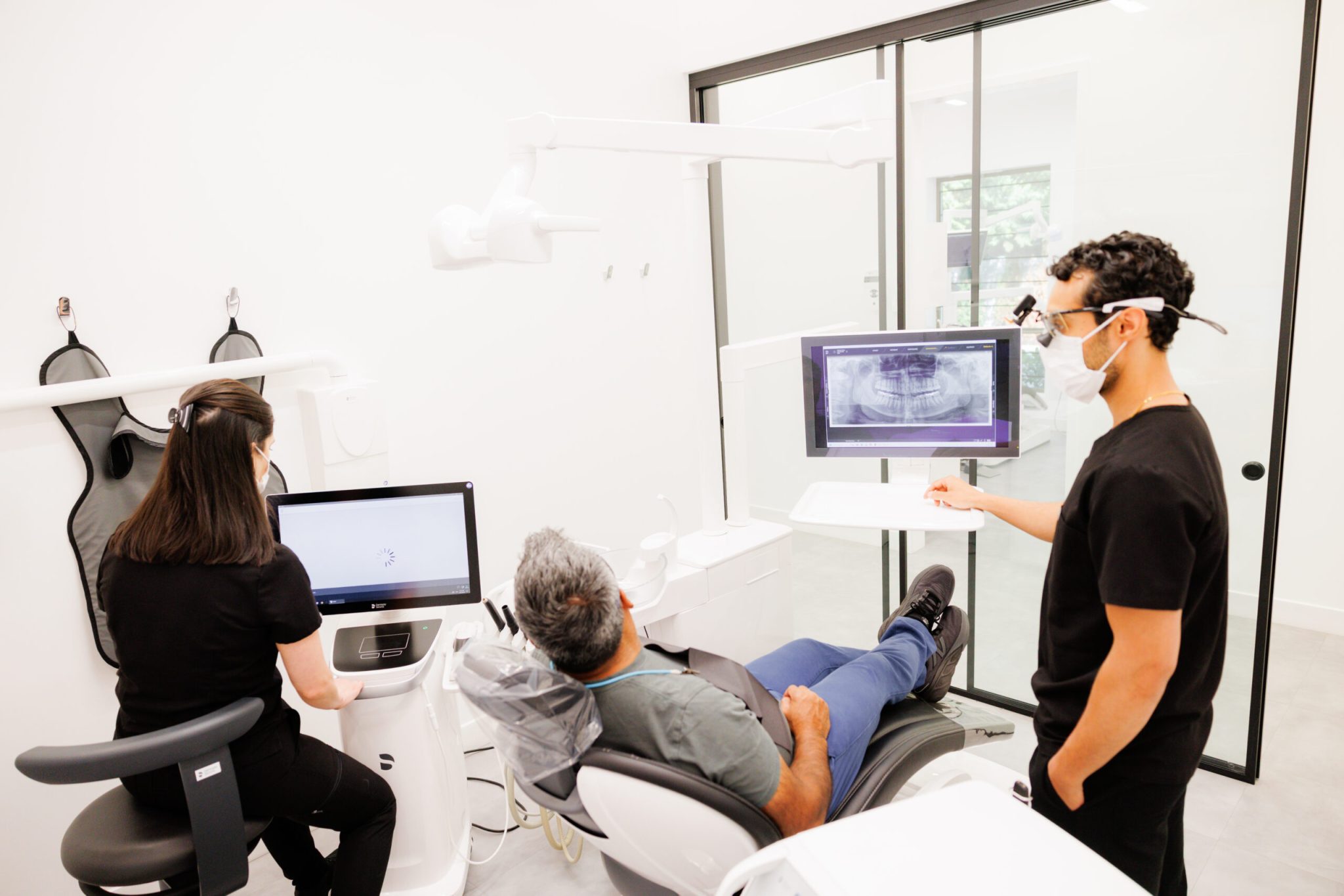A Green Apple Dental clinician reviewing a patient's 3D scan on the screen at the chair