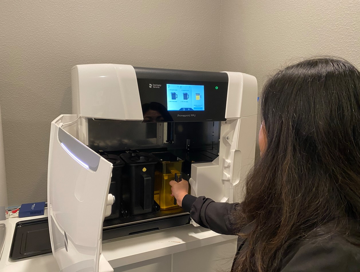 A Green Apple Dental team member with the clinic’s 3D printer